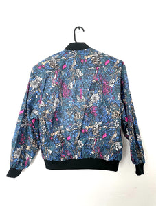 Vintage bomber jacket with jewel tone blue, pink and white floral print a front zipper and black trim on collar, sleeves and waist.